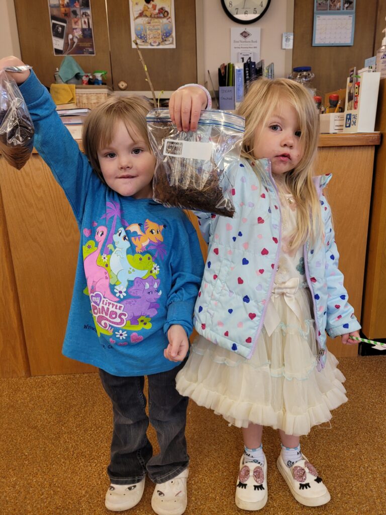 Weston County Children's Library Pollinator Program - children holding lemon basil seedlings