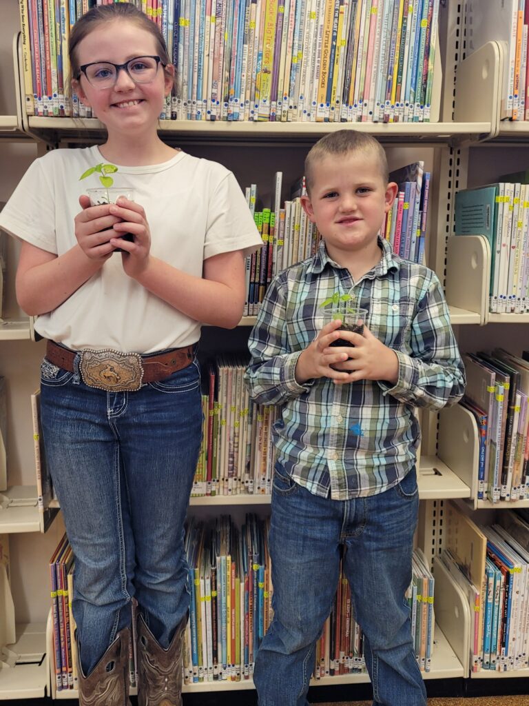 Weston County Children's Library Pollinator Program - children holding lemon basil seedlings