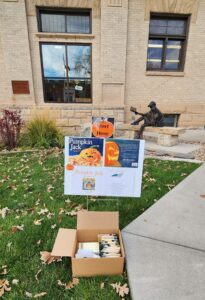 StoryWalk station with book cover for the book Pumpkin Jack by Will Hubbell and a sign that says "start here".