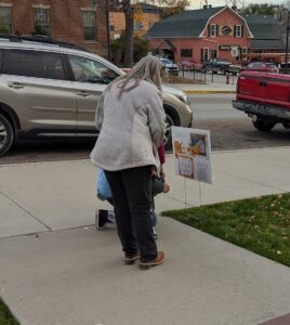 Family reading the page at the second station of the 2024 Halloween StoryWalk