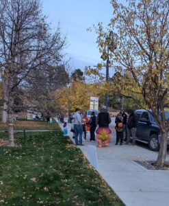 People in Halloween costumes walking on a sidewalk and visiting the WCNRD Halloween StoryWalk