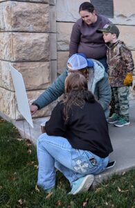 Visitors reading the book page and working to solve a puzzle